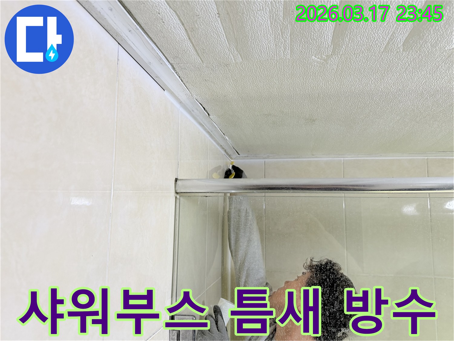 화장실 샤워부스 상단-천장 접합부에서 발생한 누수 문제를 해결하기 위해-실리콘 보수 작업을 진행하는 전문가의 모습입니다.