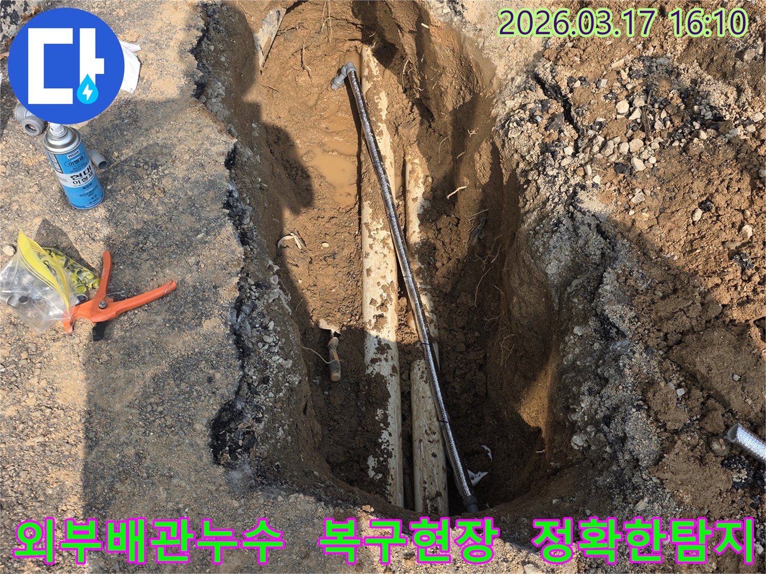 이 이미지는 양주-율정동 상가주택 외부에서 발생한 배관 누수를-정확히 탐지하고-복구하기 위한 굴착 현장을 보여줍니다.