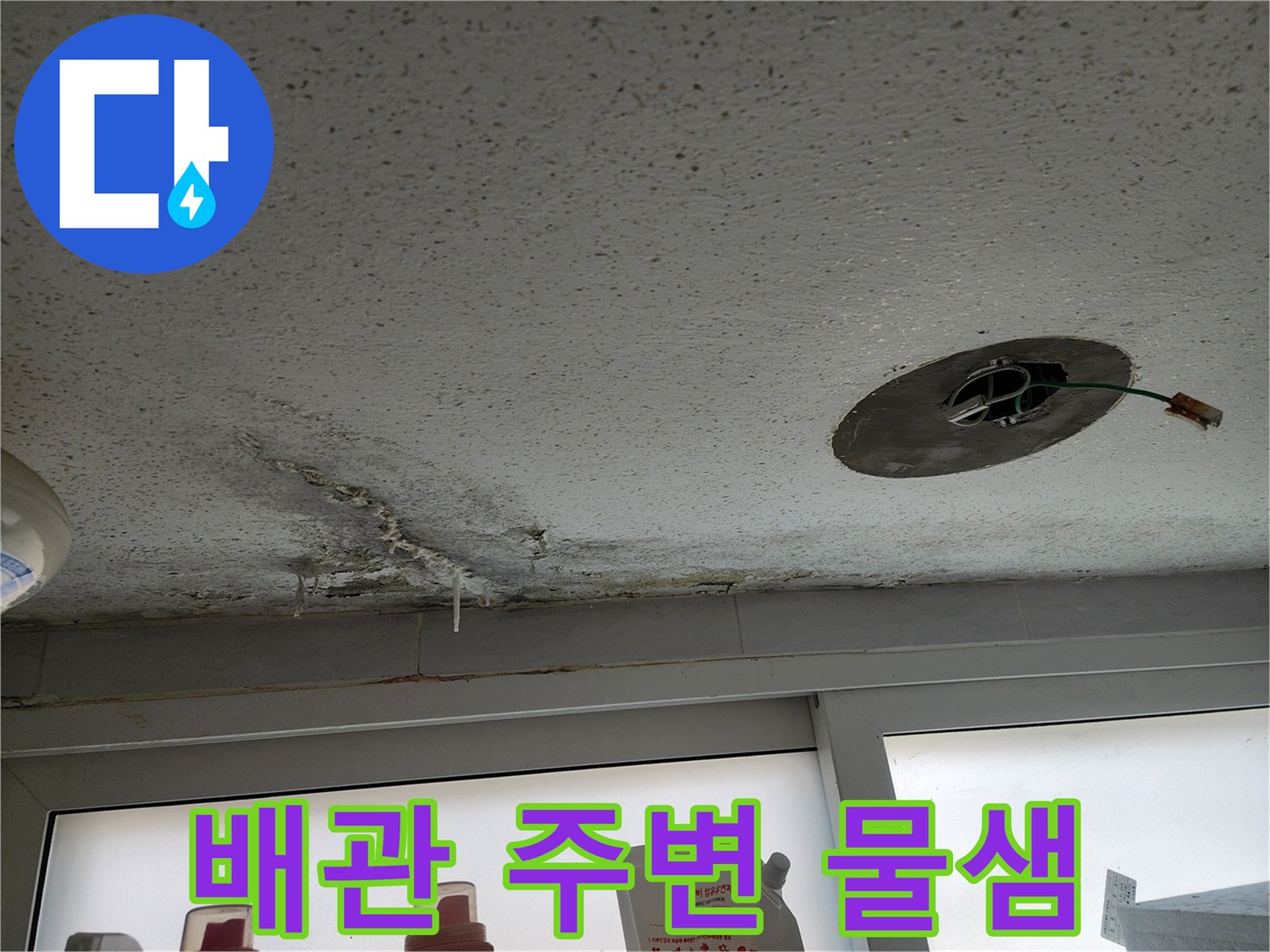 천장 배관 노출 구멍 근처의 젖은 자국과 오염된 마감재