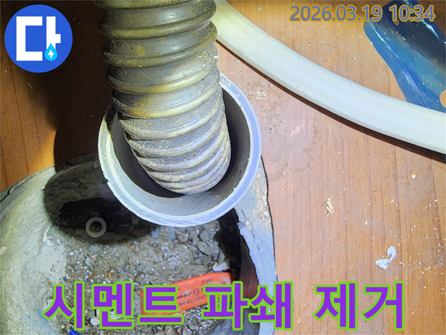 이 이미지는-성동구 사근동의-누수 현장에서-배관 주변의-시멘트를 파쇄하고-제거하는 작업을-보여줍니다