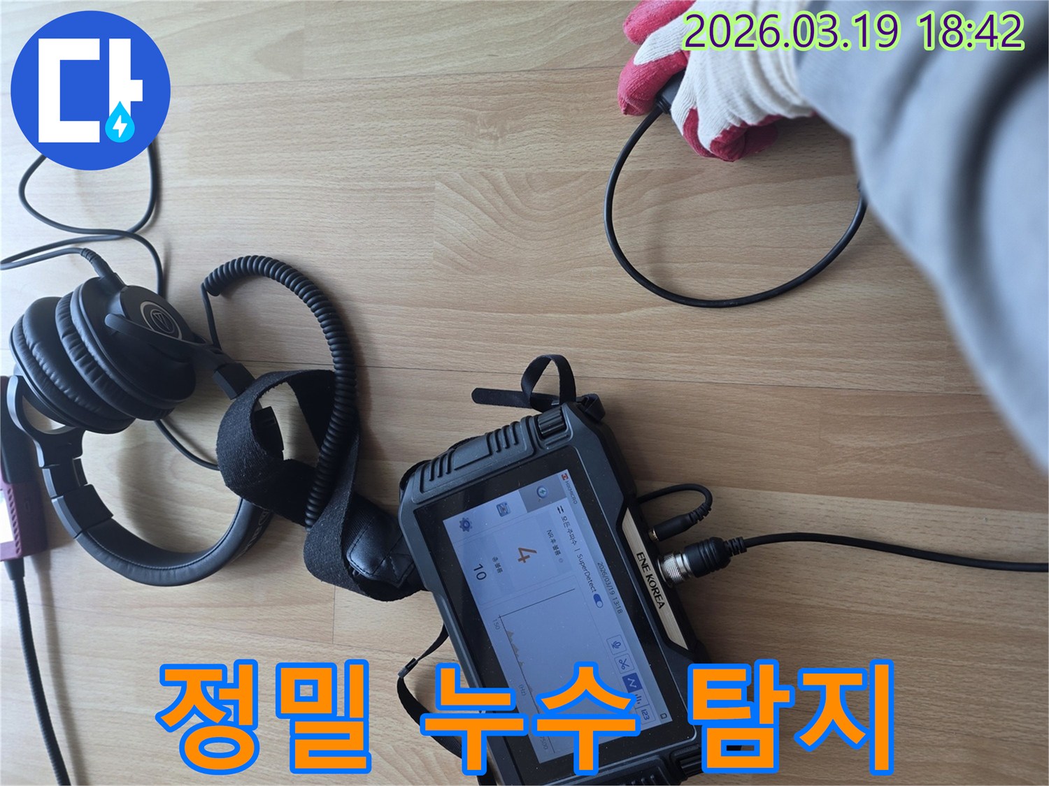 누수 탐지 전문가가-바닥에 놓인 장비와 헤드폰을 이용해-미세한 누수음을 듣고-누수 지점을 정확히 파악하는-현장 작업 모습입니다