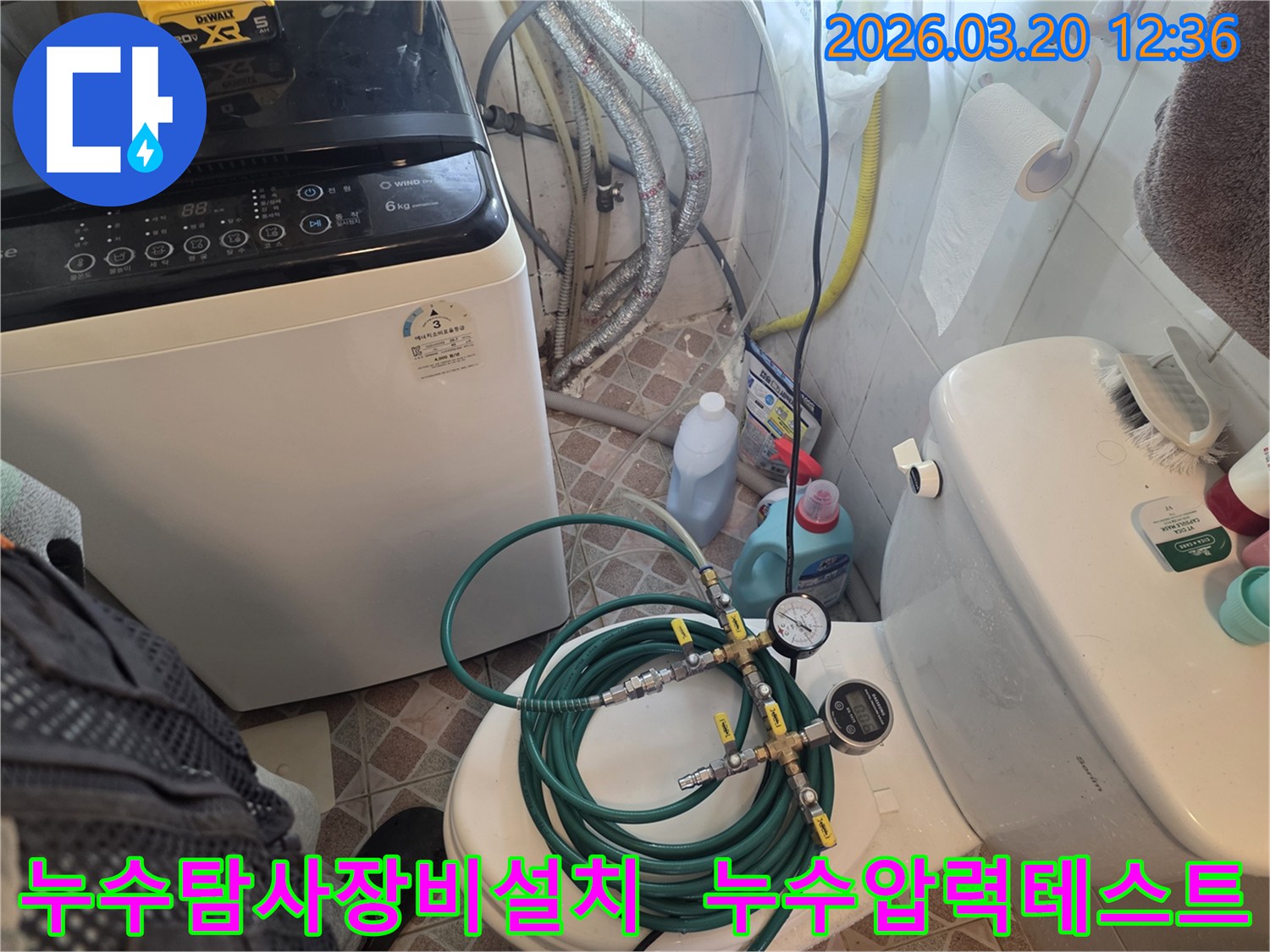 누수 엔지니어가 화장실 변기 위에-누수 탐지용 압력 게이지와 호스를 설치하여-배관의 누수 여부를 정밀하게 검사하고 있습니다