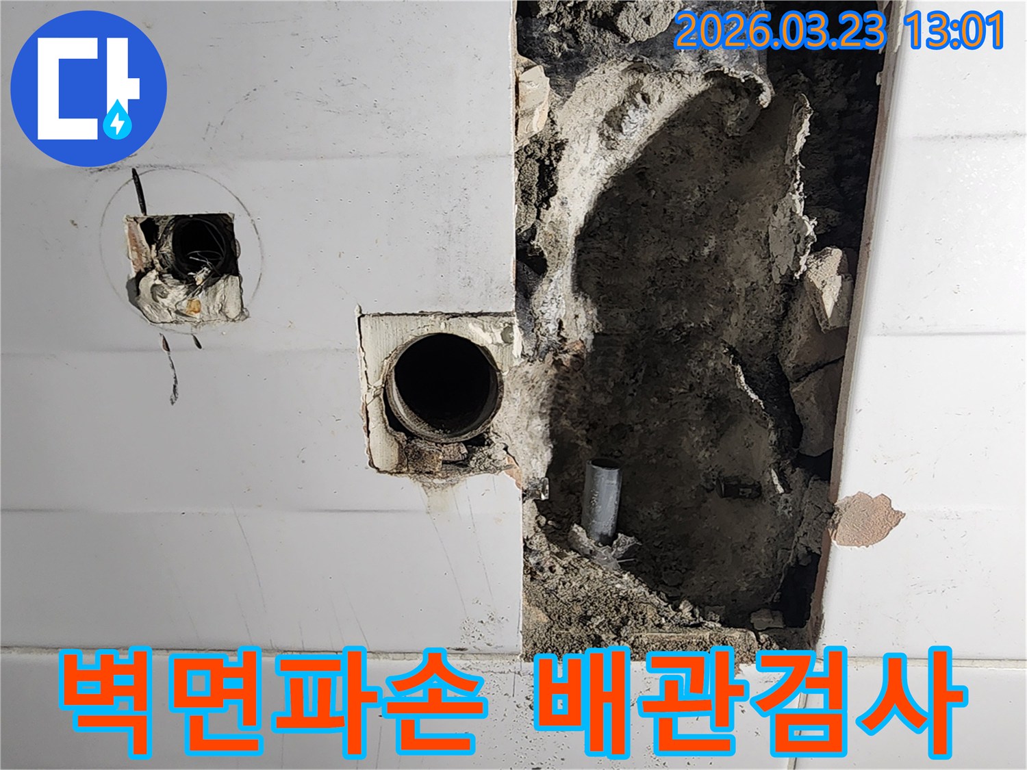 누수로 인해 벽면이 파손된 현장에서-노출된 배관의 상태를-정밀하게 검사하는 작업 모습