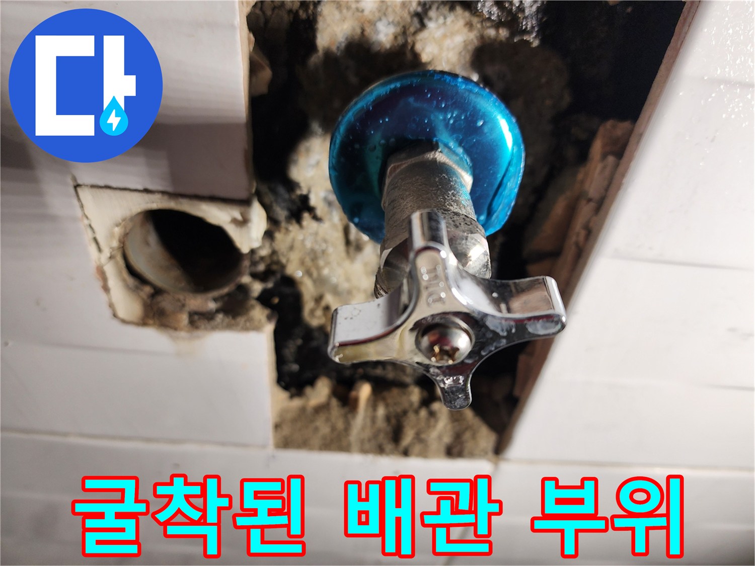 벽면 타일 제거 후 드러난 파란색 밸브와 배관 연결부