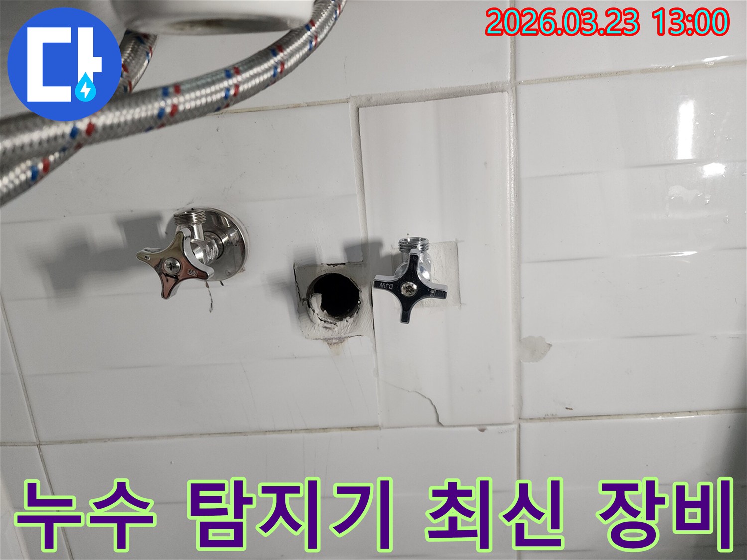 하얀색 타일 벽면의-수도 배관 연결 부위에서-누수가 확인되어-타일을 제거하고-배관을 점검하는-누수 현장입니다.
