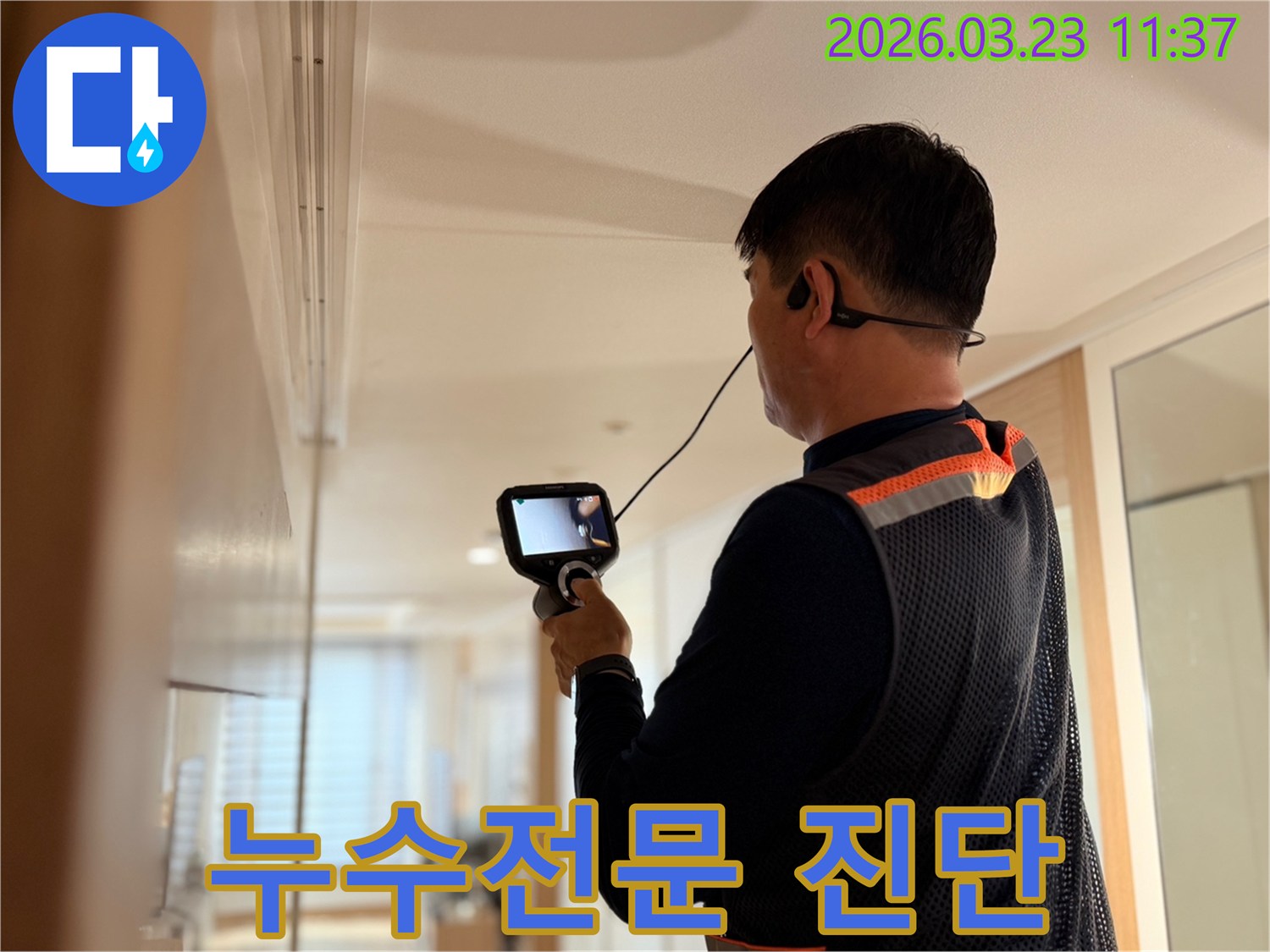 누수탐지 전문 엔지니어가 고성능 탐지 장비로 건물 내부의 누수 지점을 정확하게 진단하며 고객의 신뢰를 얻는 모습