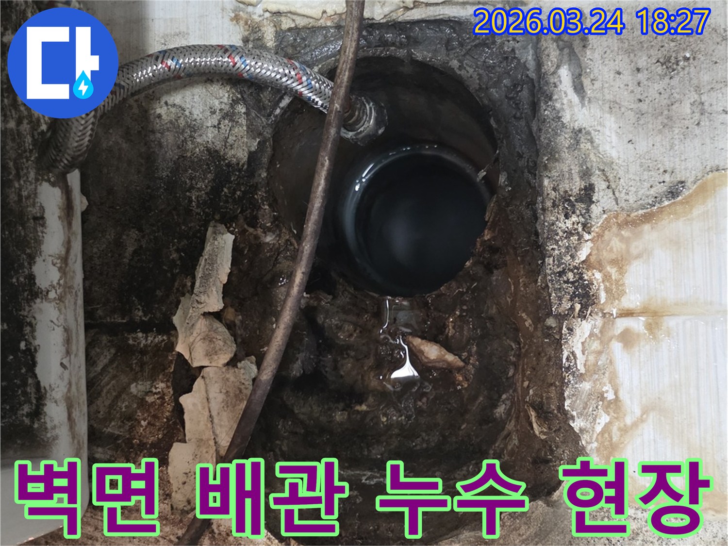 오래된 주택의 벽면에서 발견된 심각한 배관 누수-손상된 배관과 주변 벽면의 물때가 명확하게 보입니다.