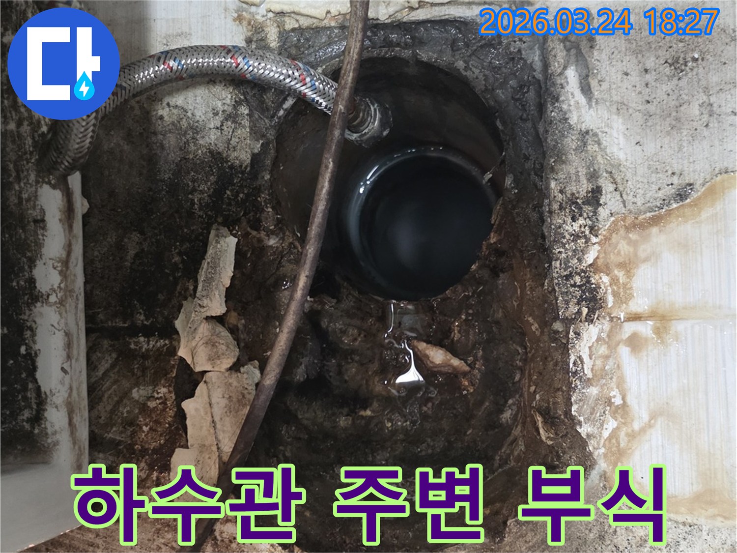 오래된 하수관 주변 벽면이 물에 젖어-심하게 부식되고 손상된 상태를 보여줍니다.