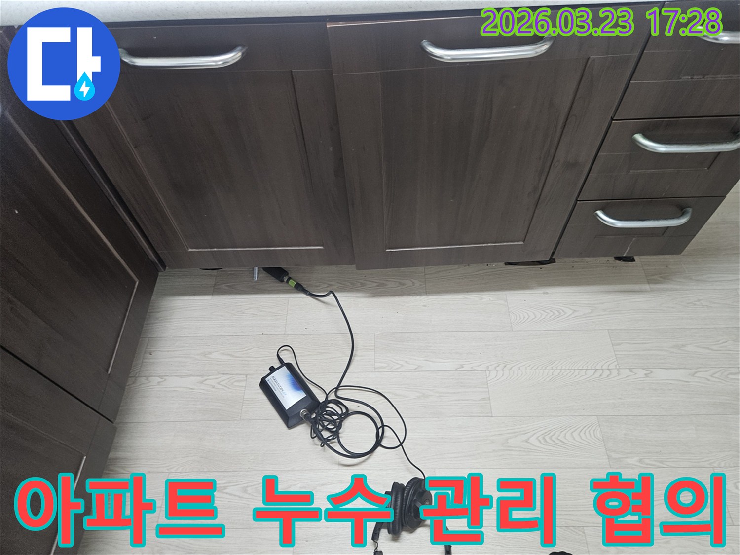 용인 기흥구 아파트 주방 싱크대 하부에서-관리 사무소와의 협의를 위한 누수를-청음식 탐지 장비로-정확하게 진단하는 엔지니어의 모습