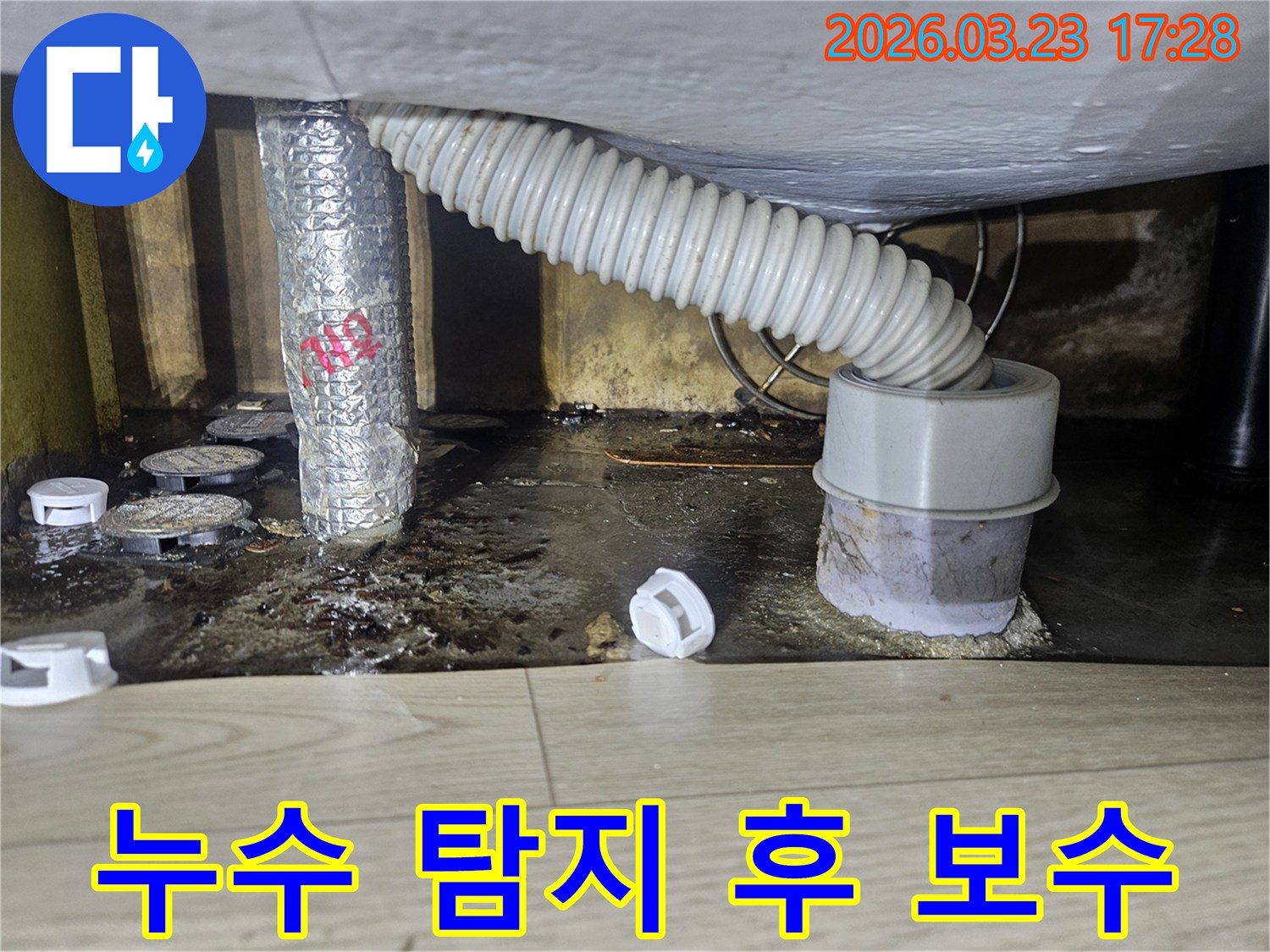 이 이미지는 누수 탐지 후 배관 보수 작업을 위해 주변이 정리되고 오염된 바닥을 보여주며-재발 방지를 위한 시공이 진행됩니다.