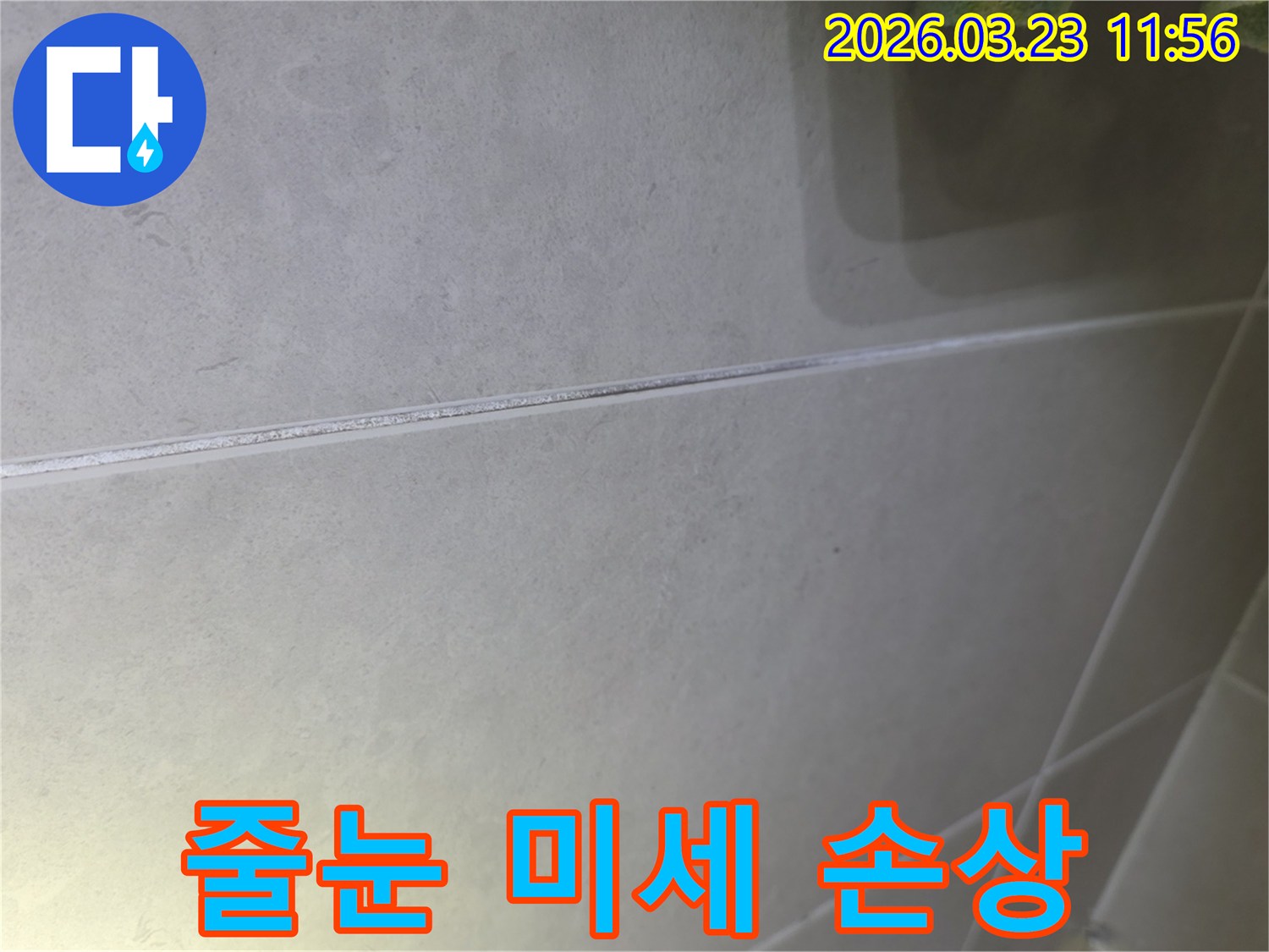 타일 줄눈의 미세한 손상 부위를-가까이서 촬영한 현장 사진입니다.