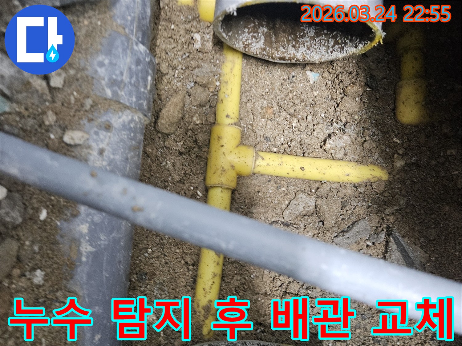 깊이 파헤쳐진 땅속에서-노란색 수도관과-회색 PVC 배관이-복잡하게 연결된-누수 현장의 모습입니다.