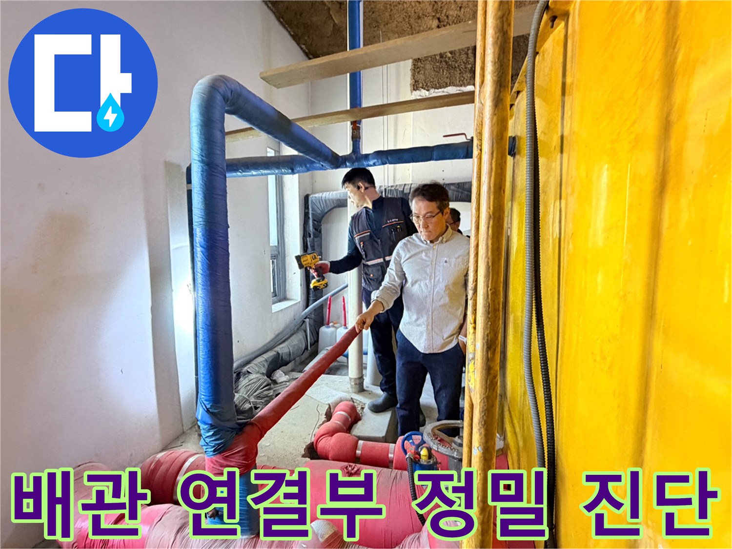 분홍색 보온재 배관 아래에서 작업자가 배관의 결합 상태를 손으로 짚어가며 확인합니다.