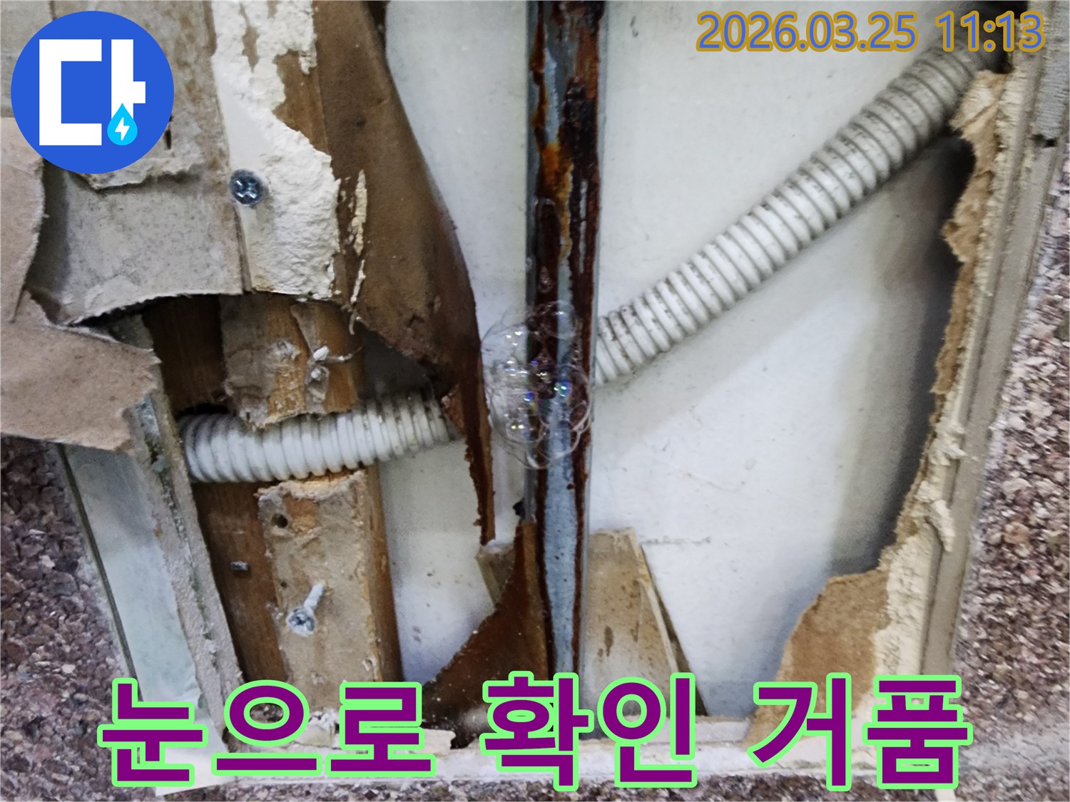 배관에서 새어 나오는 물과 공기가-비눗물과 만나-거품으로 변하여-누수 지점을 눈으로 명확히 보여주는 장면입니다