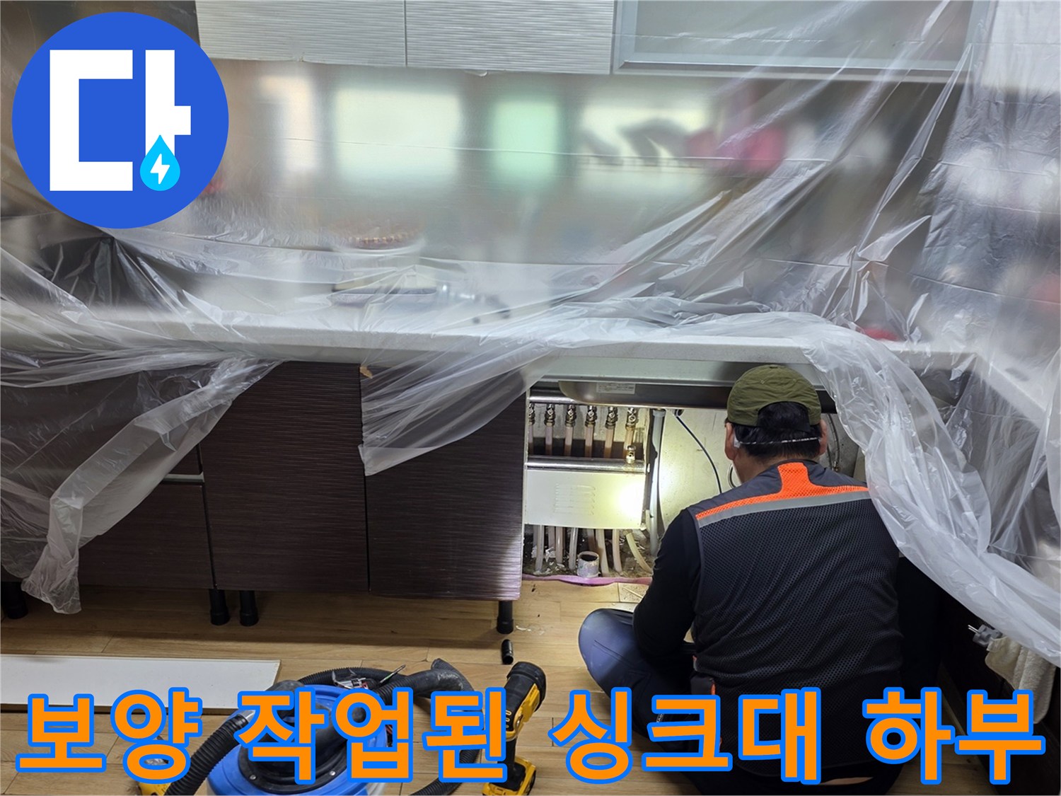 싱크대 아래쪽 배관 주위를 비닐로 덮어둔 공사 현장