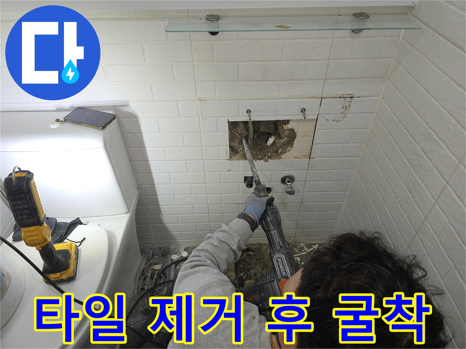 세면대 주변 타일을 탈거하고 내부 배관 노출을 위해 벽체를 깎아내는 작업입니다.
