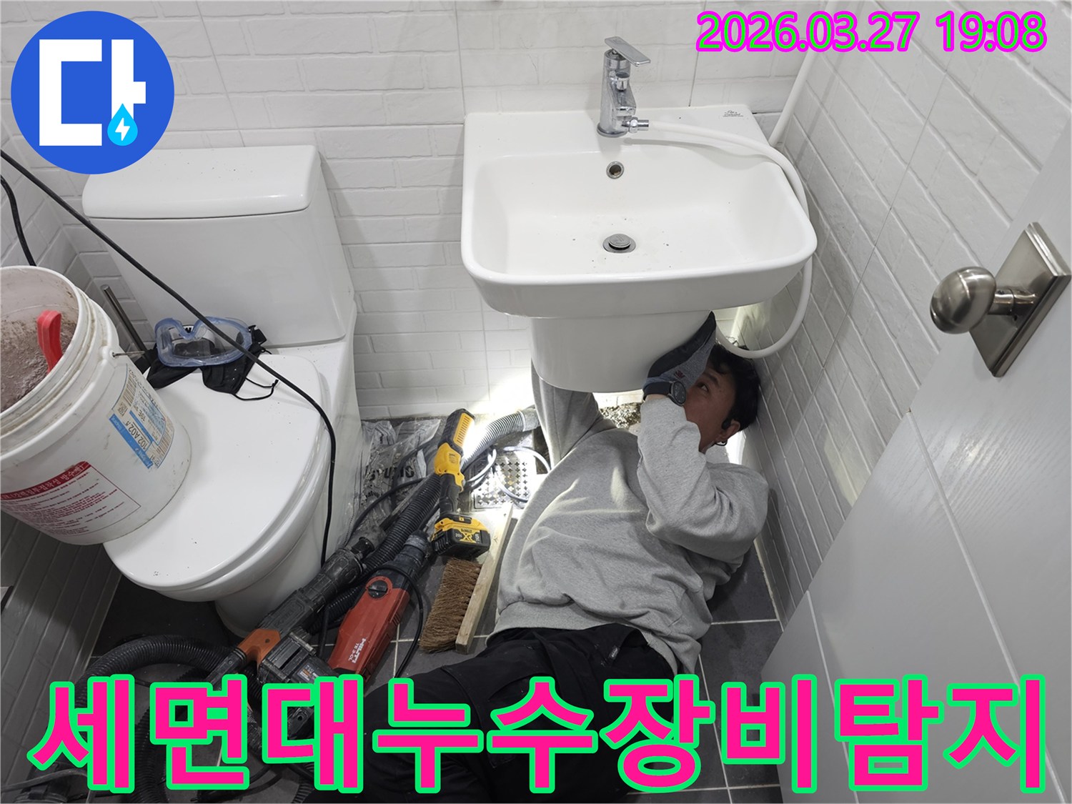 화장실 세면대 아래에서-전문 장비를 활용하여-누수 지점을-정밀하게 탐지하는-엔지니어의 모습