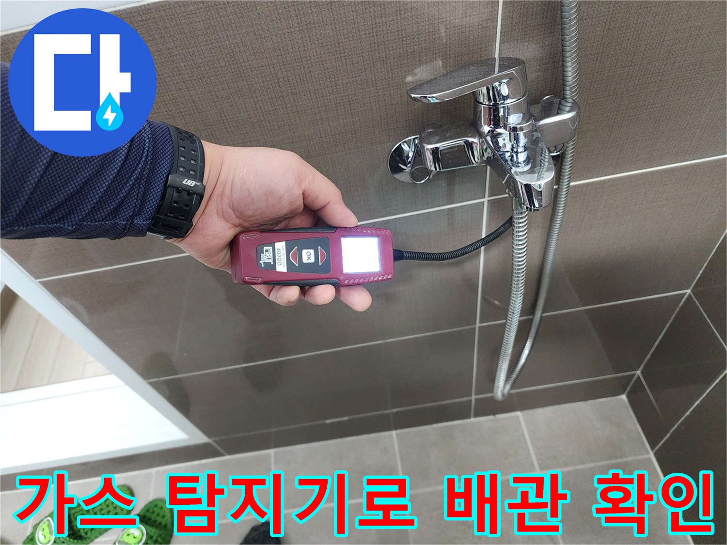 샤워기 수전 근처에서-가스 탐지기를 사용하여-매립 배관의 누수 지점을 추적하는 모습