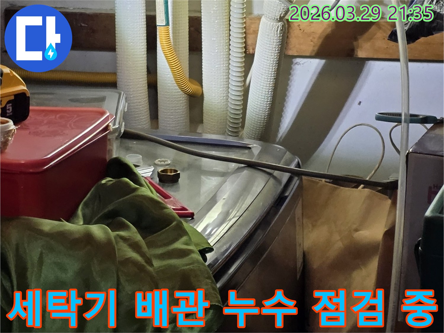 세탁기-뒤편의-수도-연결부와-가스관-주변에서-누수-여부를-확인하는-모습
