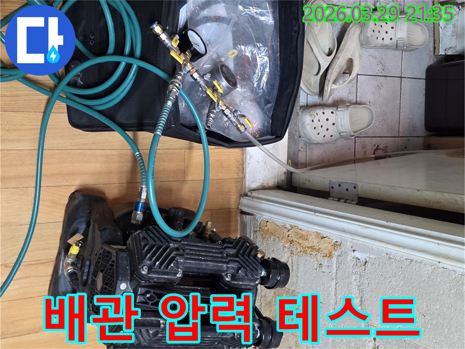 정확한 누수 지점 파악을 위해 압력 게이지와 공기 압축기를 연결하여 배관 테스트를 진행하는 모습