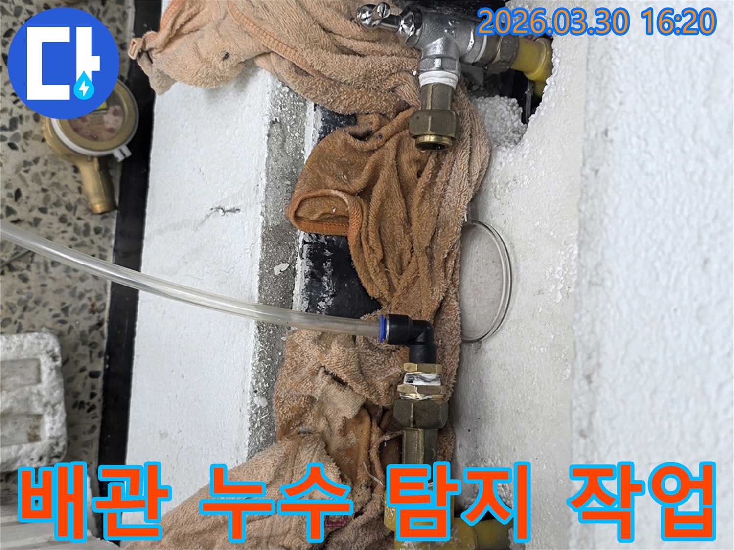 누수 탐지를 위해 배관에 연결된 장비와 주변 환경을 보여주는 사진입니다