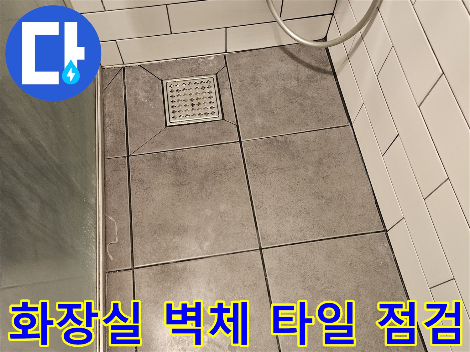 회색 타일 표면의 미세한 얼룩과 줄눈 상태를 촬영한 사진입니다.