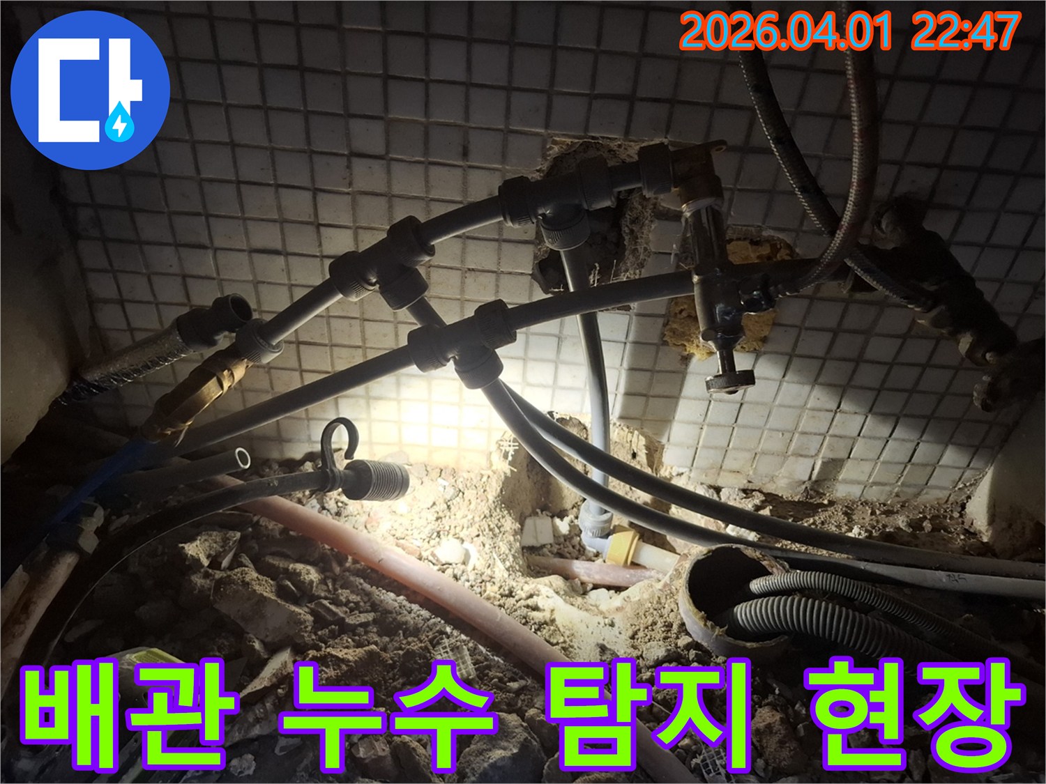 어두운 공간에서-누수 지점을 찾기 위해-배관 주변을 탐색하는 모습
