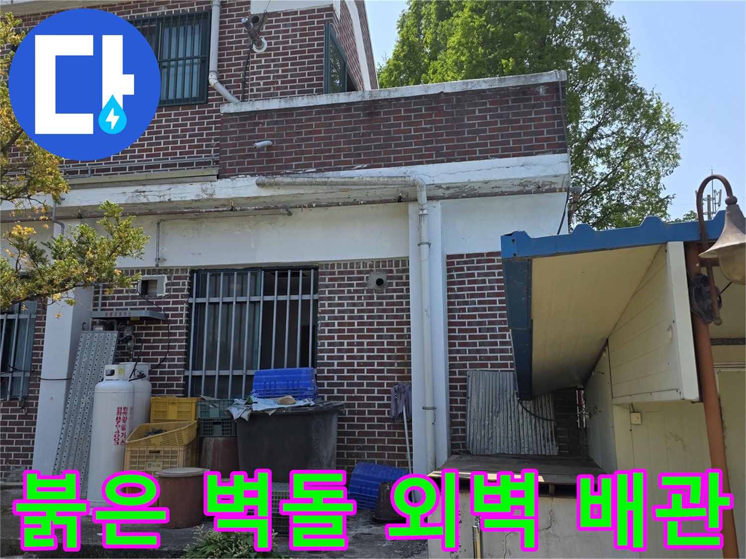 양주 백석읍 건물의 붉은 벽돌 벽면과 외부로 연결된 급수 시설입니다.