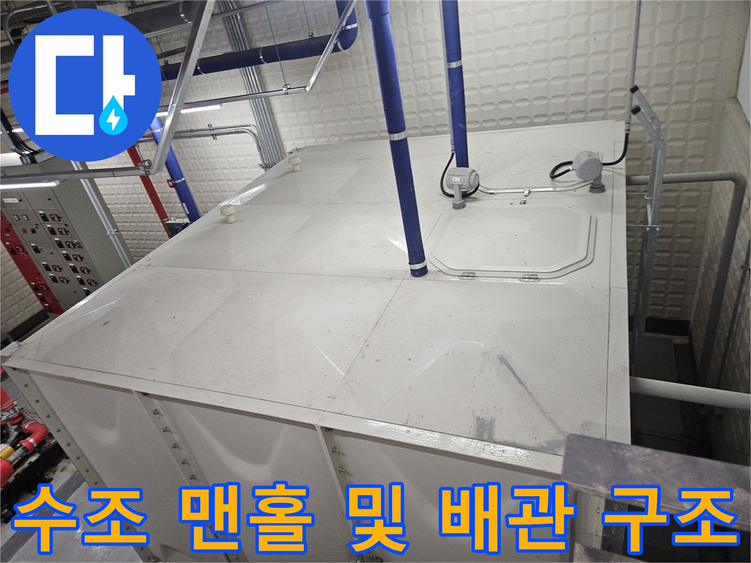 수조 상단 맨홀 덮개와 파란색 입상 배관-누수 지점 확인을 위한 설비실 점검 모습
