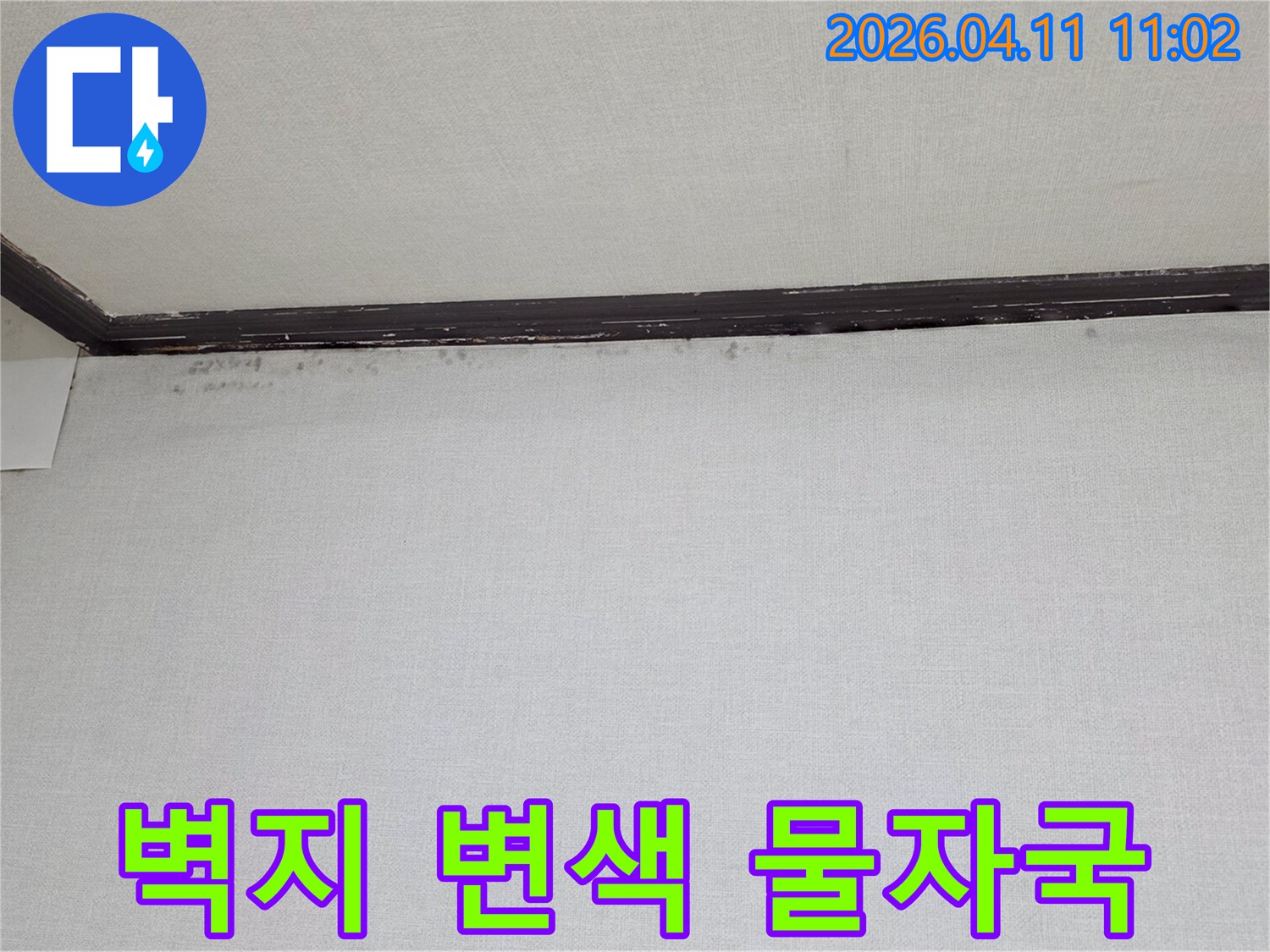천장과-벽면-경계에-나타난-벽지-변색과-어두운-물자국을-보여주는-누수-현장-사진입니다