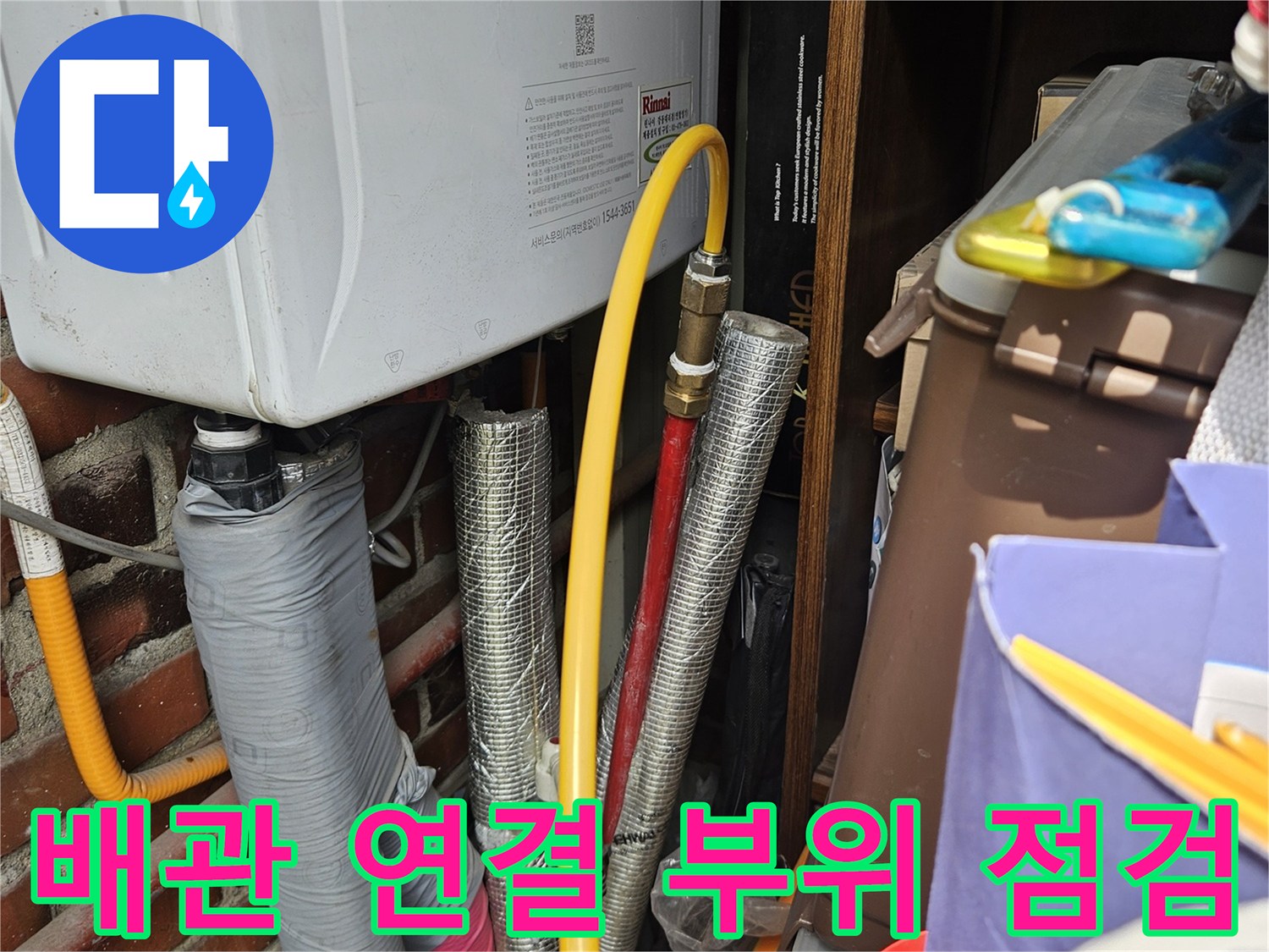 은박 보온재로 마감된 배관과 노란색 호스의 연결 상태를 근접 촬영한 사진