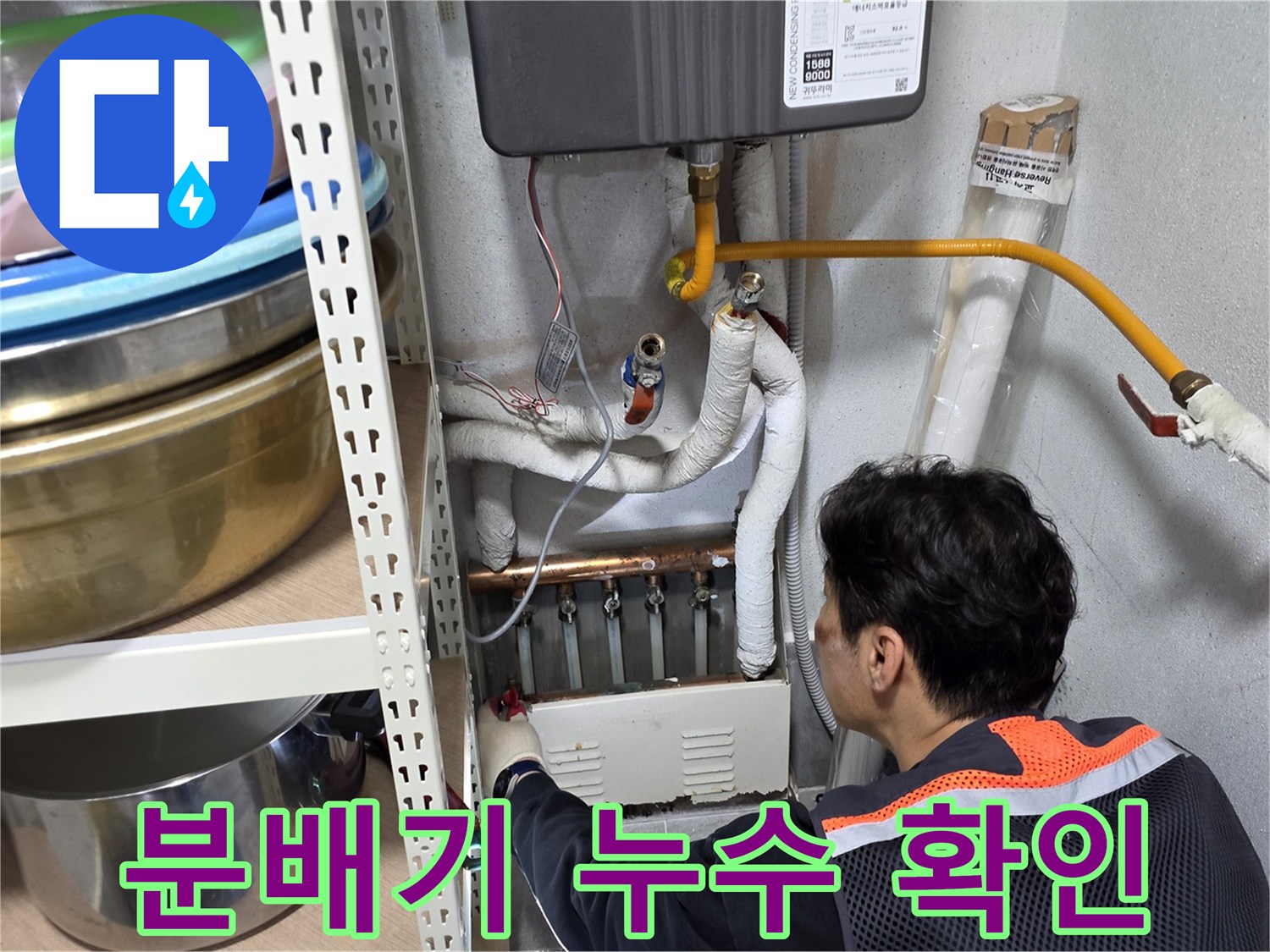 엔지니어가 보일러실 분배기 하단 연결 부위를 집중적으로 조사하고 있습니다.