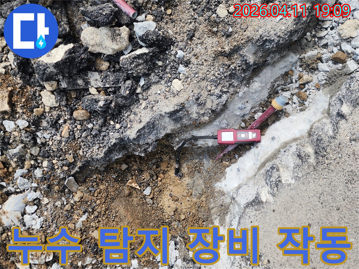 굴착된 지면 위에서-붉은색 누수 탐지 장비가-정확한 누수 지점을-측정하고 있습니다