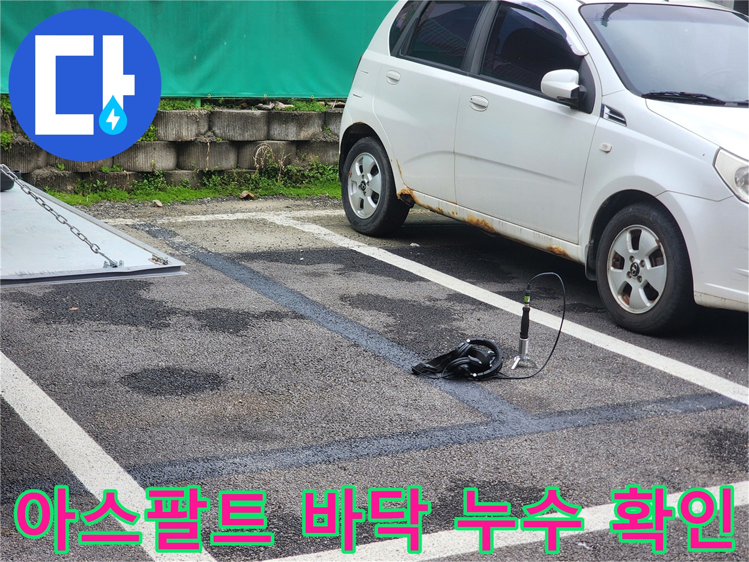 아스팔트 지면에 나타난 어두운 습기 자국과 탐지 장비의 배치 상황