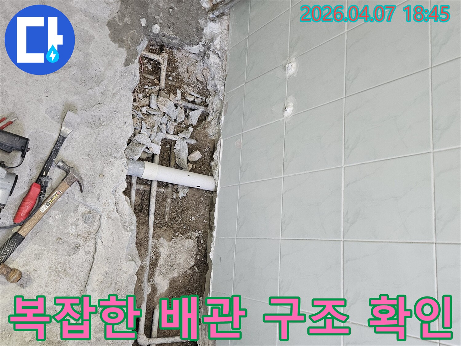 바닥 파쇄 후 드러난 복잡한 배관 시스템과-누수 지점 주변의 콘크리트 잔해가 보이는-누수 공사 현장