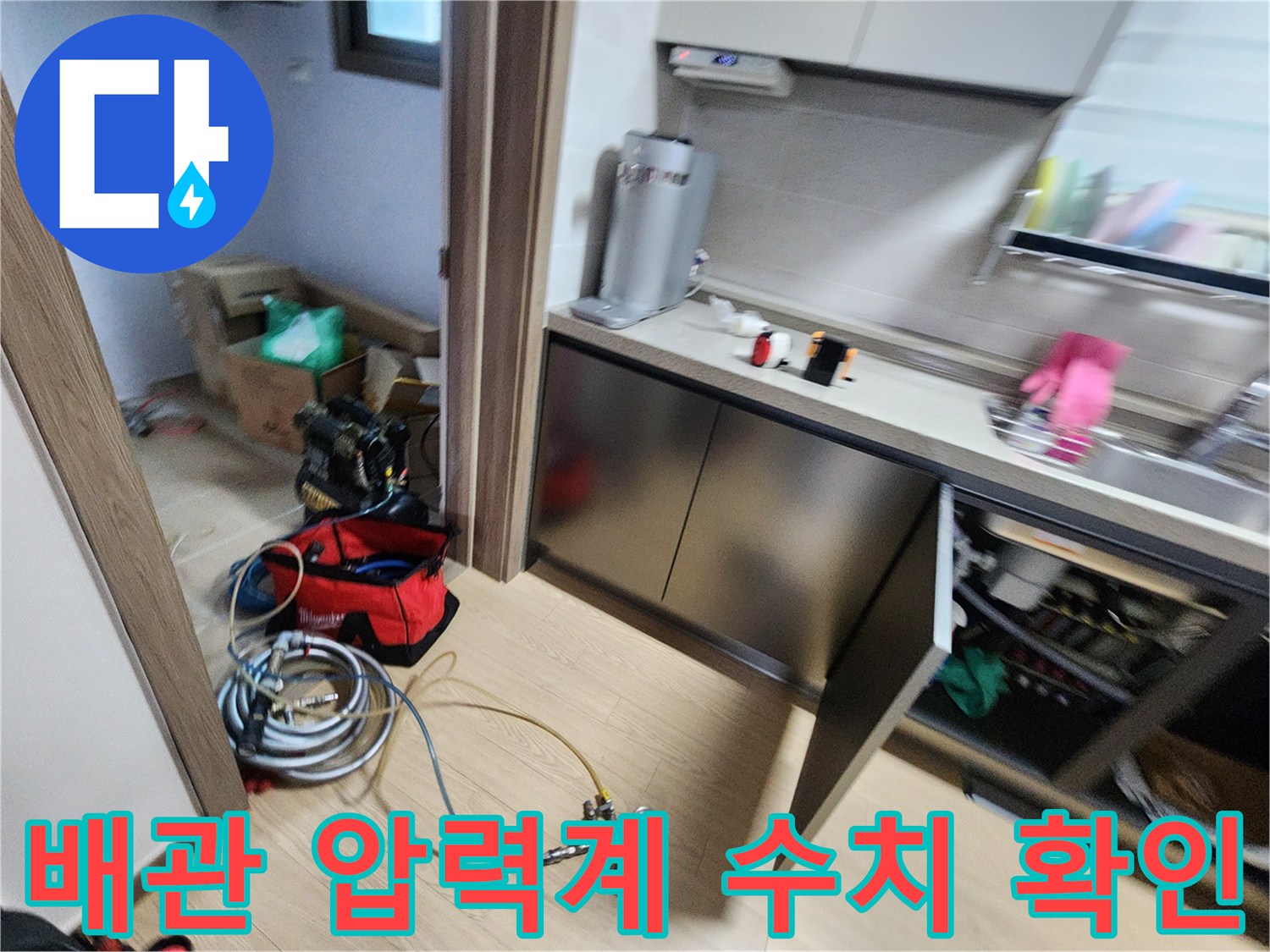 싱크대 하단 작업 공간에 배치된 누수 탐지용 게이지와 호스 연결 상태