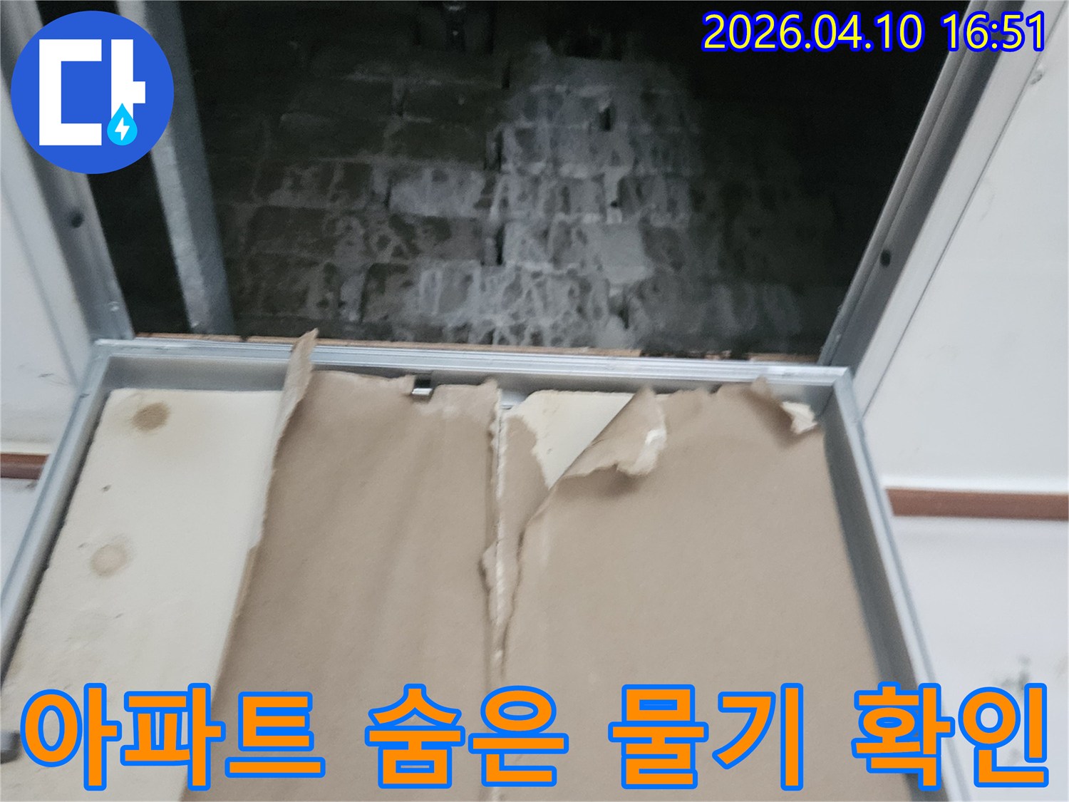 경기 포천시 일동면의 한 아파트에서-누수 문제로-점검구를 열어-숨겨진 공간의-물기 여부를 확인하는-작업 현장 사진입니다