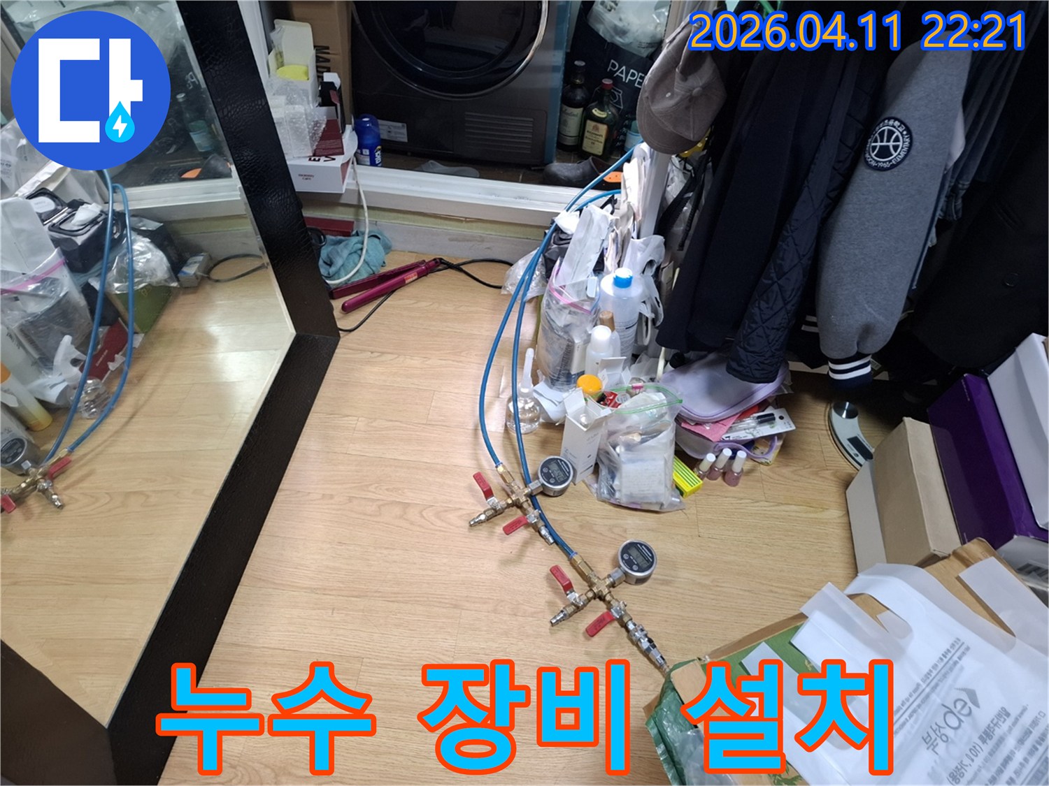 이 이미지는-누수 탐지를 위해-전문 장비를 설치하고-압력 테스트를 준비하는-현장 모습을 보여줍니다.