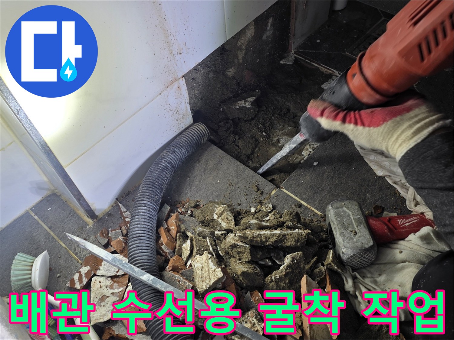망치와 도구를 사용하여 파손된 배관을 노출시키기 위해 바닥을 깨는 과정입니다.