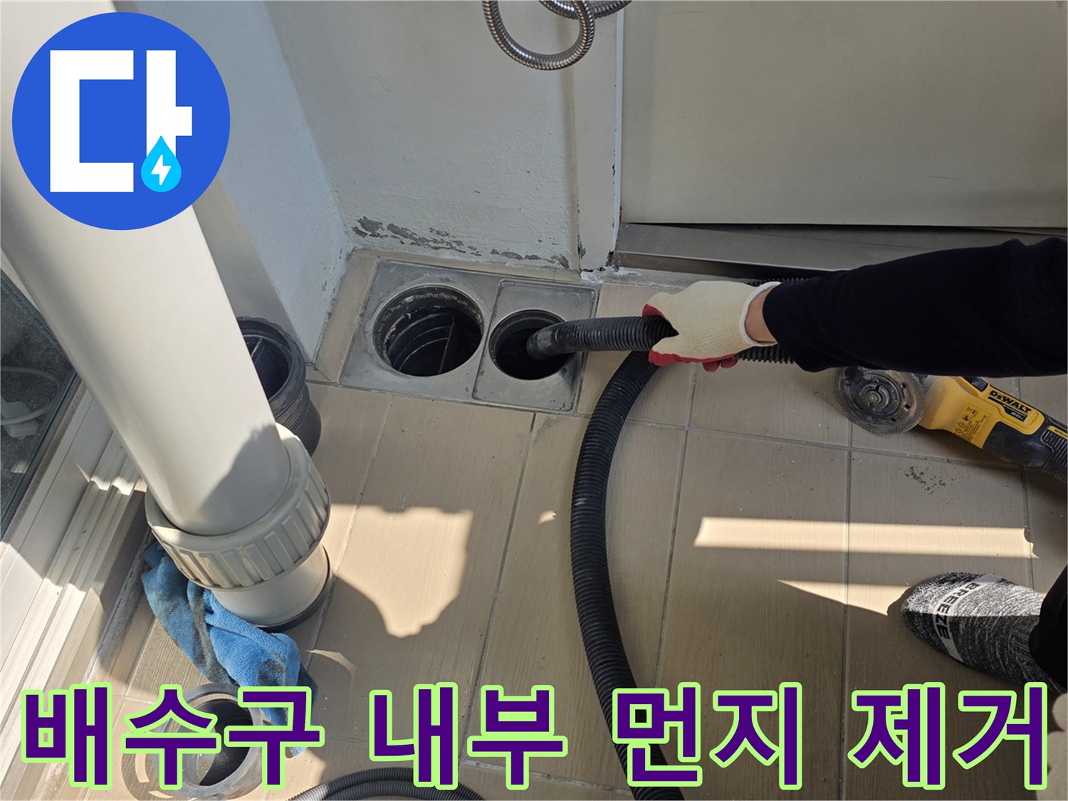 진공청소기를 사용하여 배수구 주변의 잔여물을 흡입하는 모습