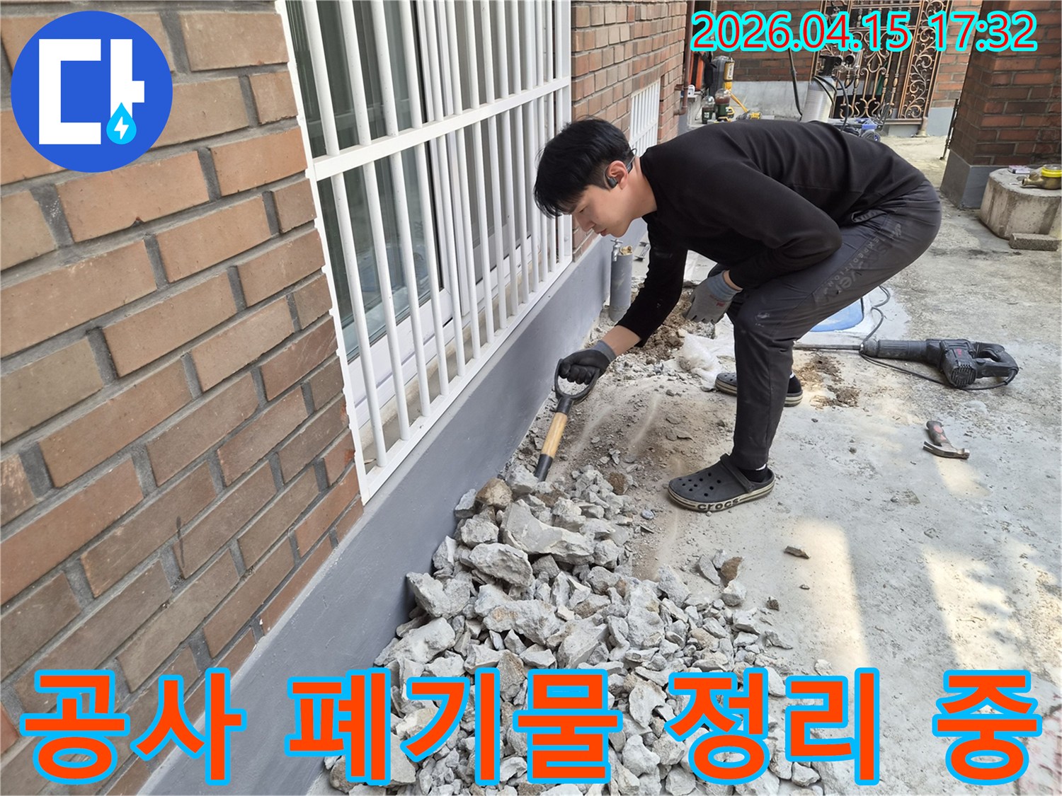 누수 공사 현장에서-작업자가 발생한 폐기물을 정리하여-안전한 작업 환경을 조성하고 있습니다