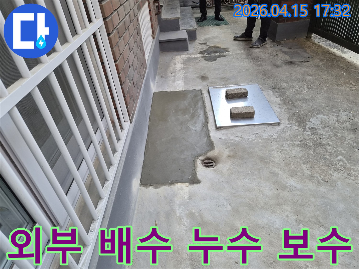 이 이미지는 성동구 장터1가길 주택의 외부 배수 시스템에서 발생한 누수를 해결하고-새로운 시멘트로 깔끔하게 마감한 현장을 보여줍니다.