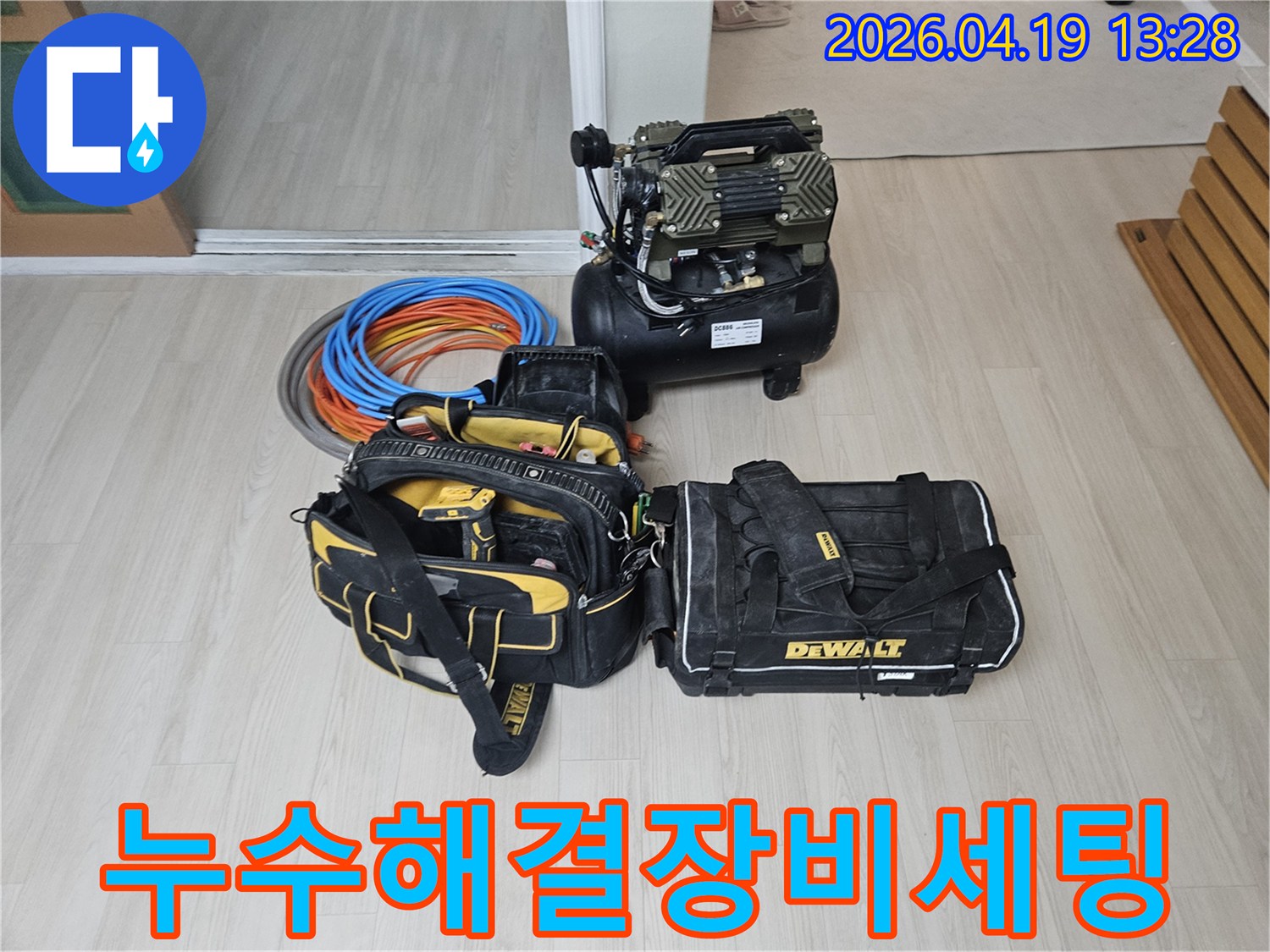 누수 해결을 위한-모든 전문 장비들이 바닥에 준비되어 있습니다-에어 컴프레서와-다양한 공구-그리고 교체용 배관 자재들이 보입니다.