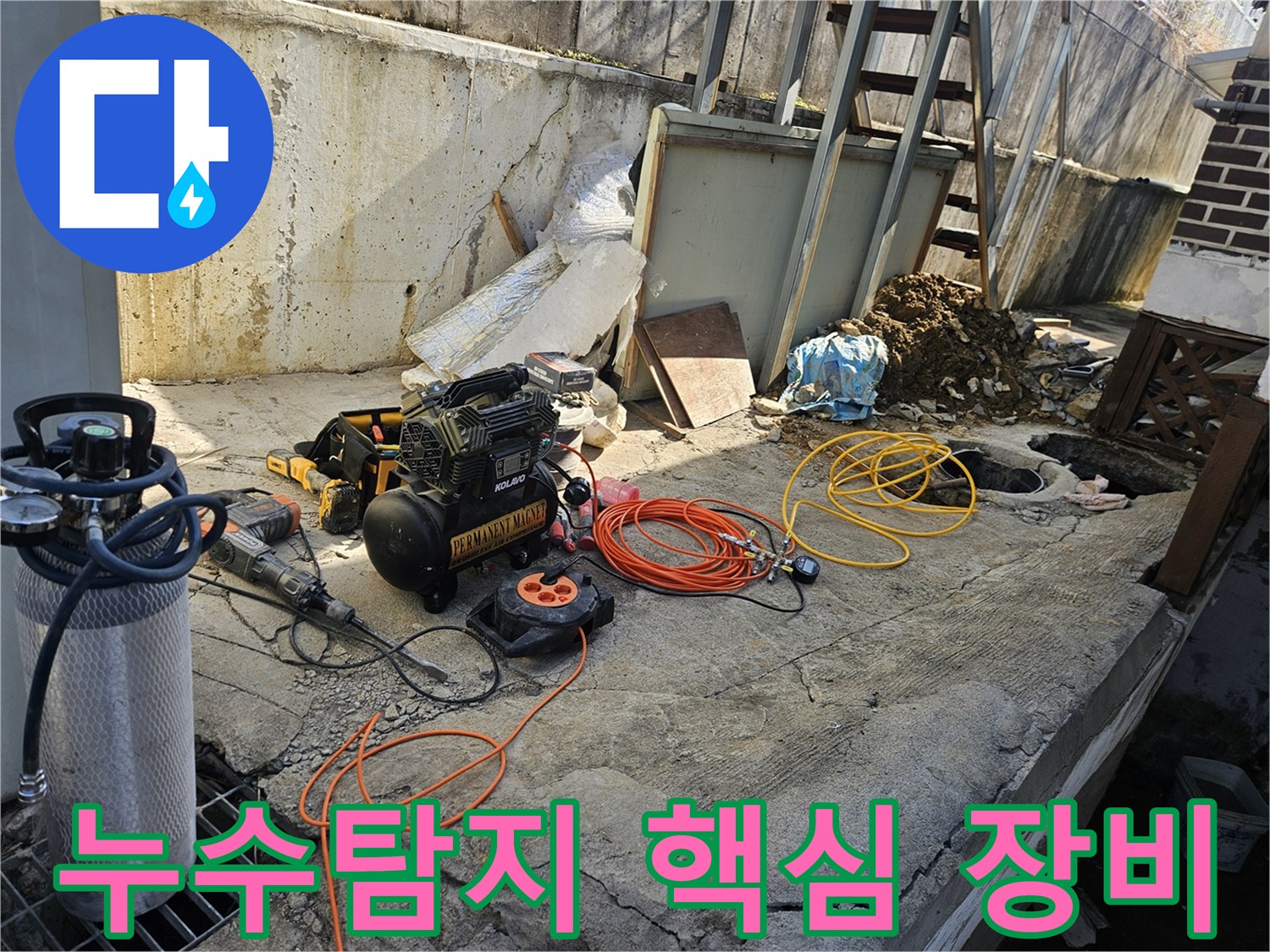 누수 공사를 위한-에어 콤프레셔-함마드릴-호스-전선릴 등-다양한 전문 장비들이-콘크리트 바닥 위에-정돈되어 있는-작업 준비 현장