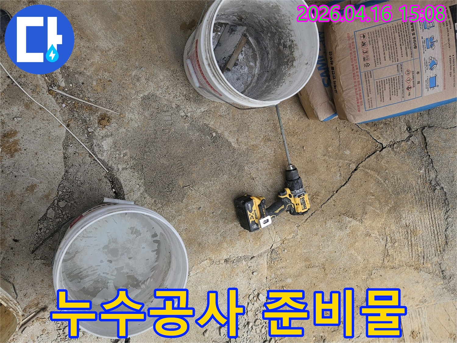 누수 보수 작업을 위한 시멘트와-혼합 장비-그리고 물통이 준비된 모습