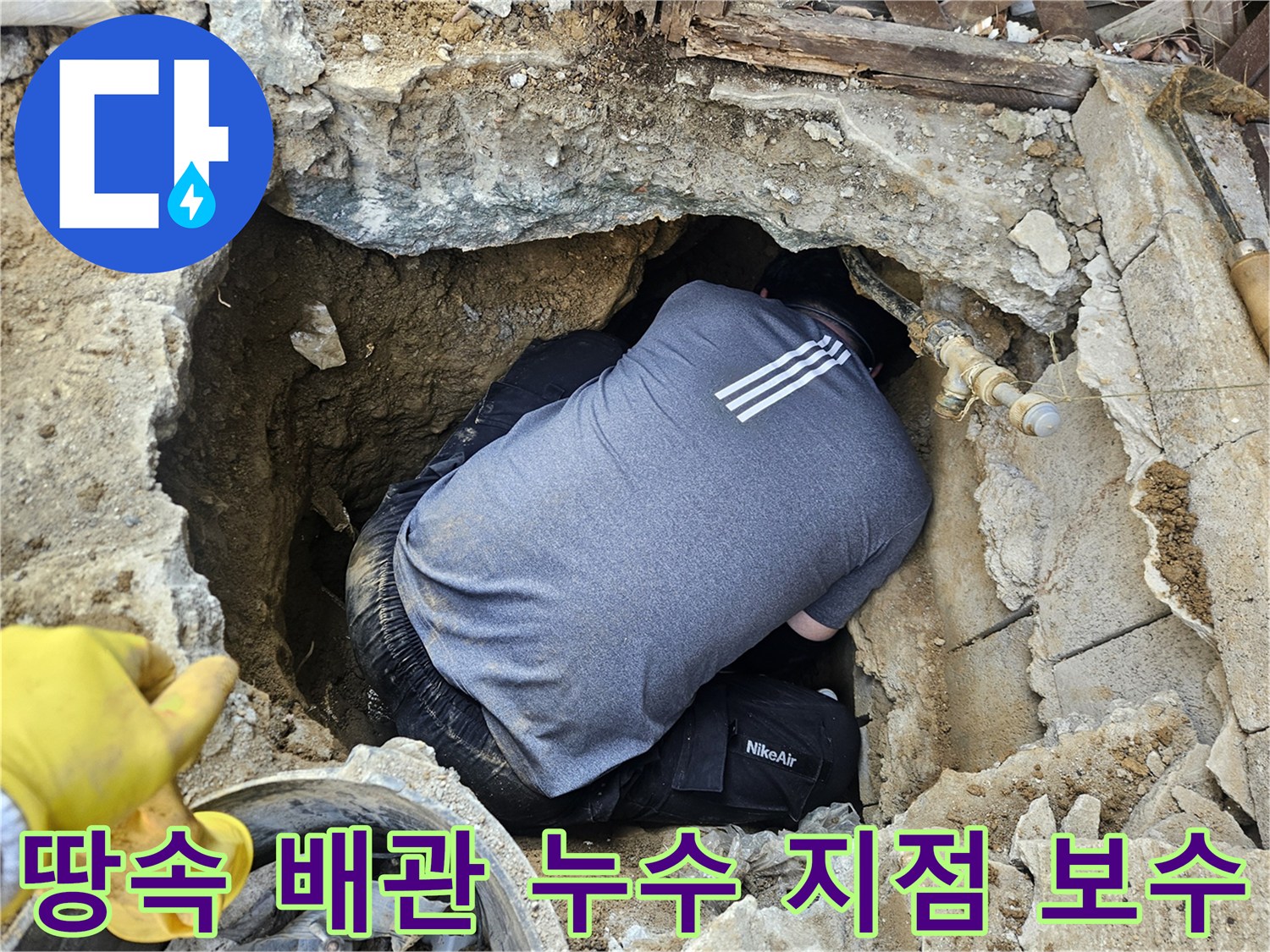 숙련된 누수 엔지니어가-땅속에 매설된 배관의-누수 지점을 보수하기 위해-좁은 구덩이에서 작업하는 모습