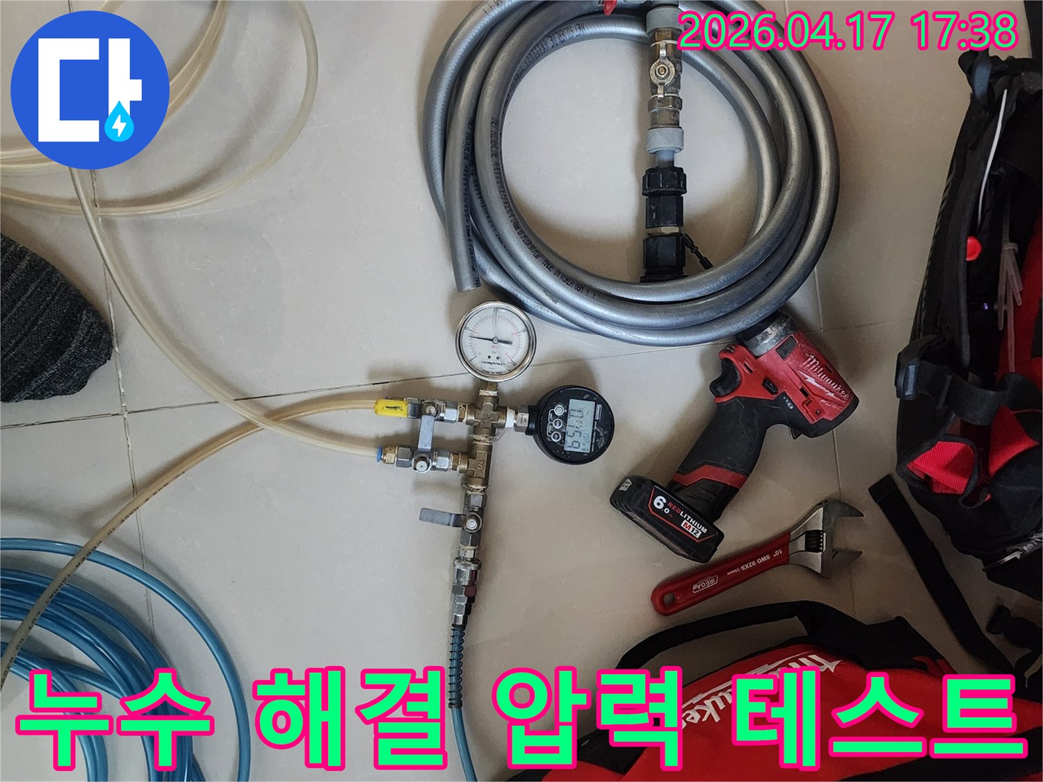 누수 문제를 해결하기 위해-압력 테스트 장비와-다양한 작업 공구들이-바닥에 준비되어 있습니다