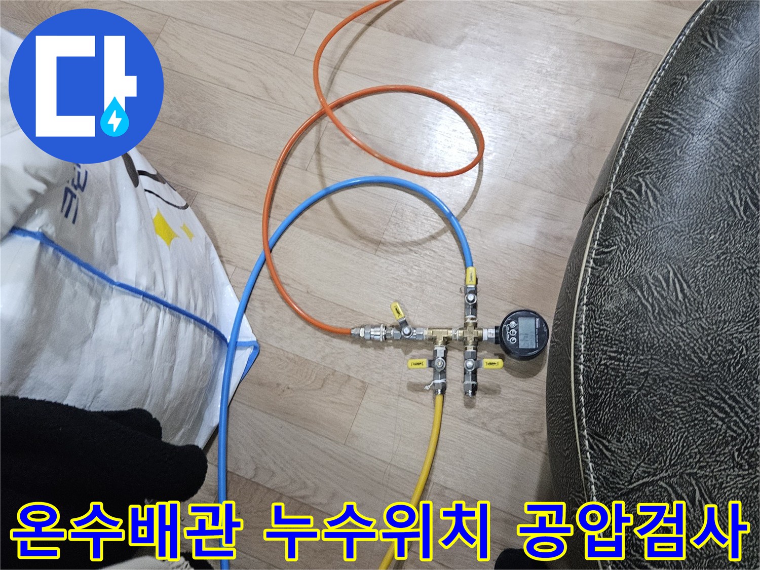 누수 엔지니어가 온수 배관의 누수 위치를 특정하기 위해-공압 검사 장비를 연결하여 압력을 측정하고 있습니다