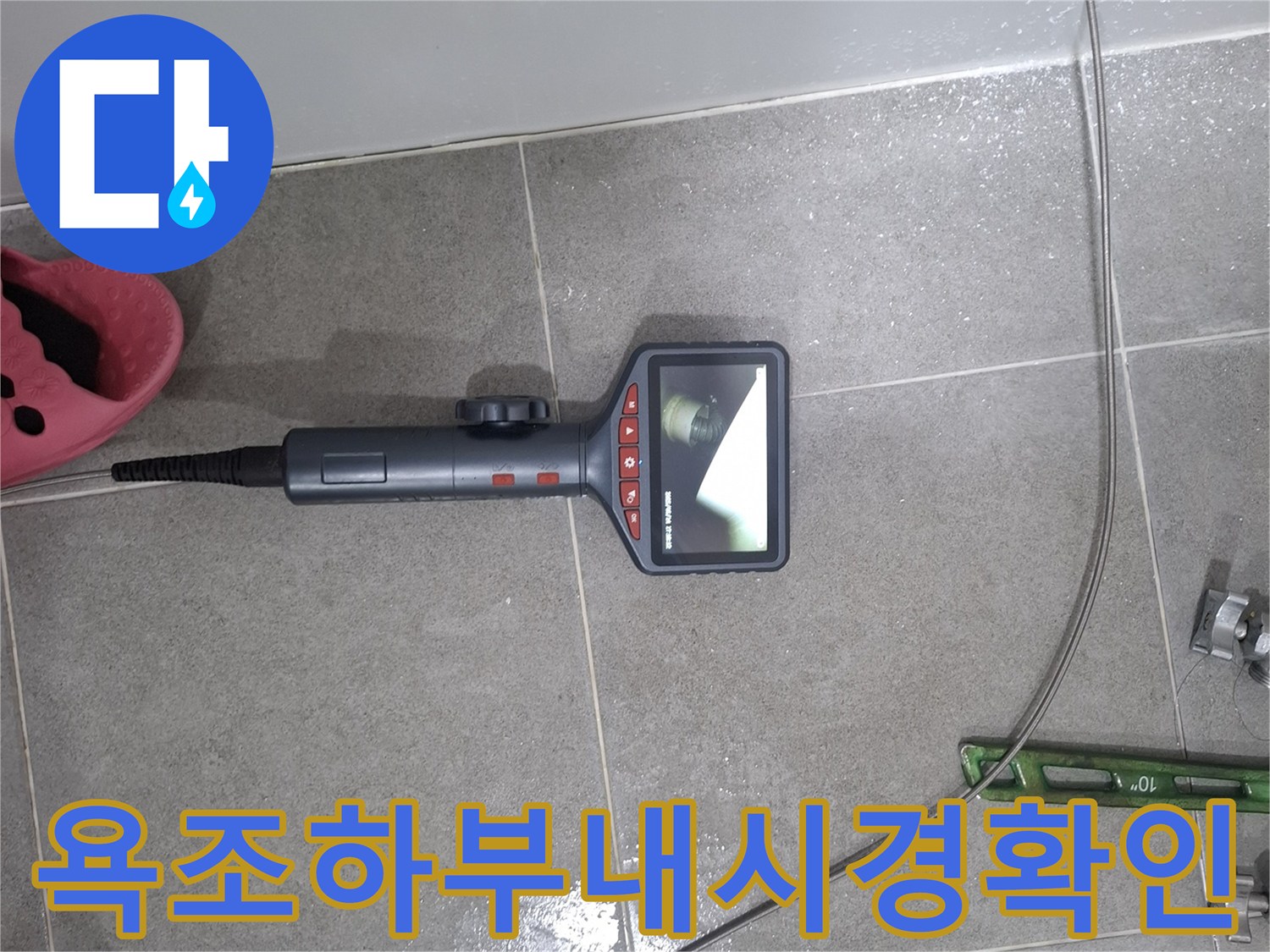 누수 엔지니어가 욕조 하부의 은밀한 누수 지점을 파악하기 위해-내시경 카메라를 활용하여-배관 내부를 면밀히 검토하는 모습