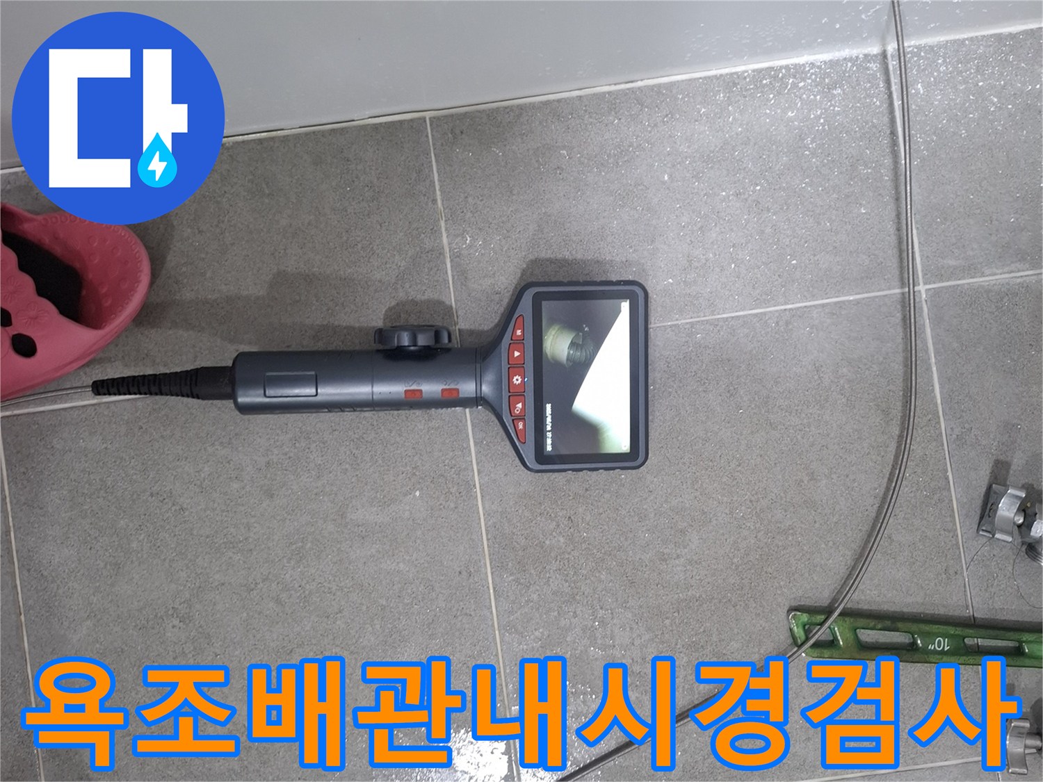 누수 탐지 전문가가 욕조 아래 배관의 상태를 확인하기 위해-내시경 카메라를 삽입하여-모니터로 내부를 관찰하는 장면